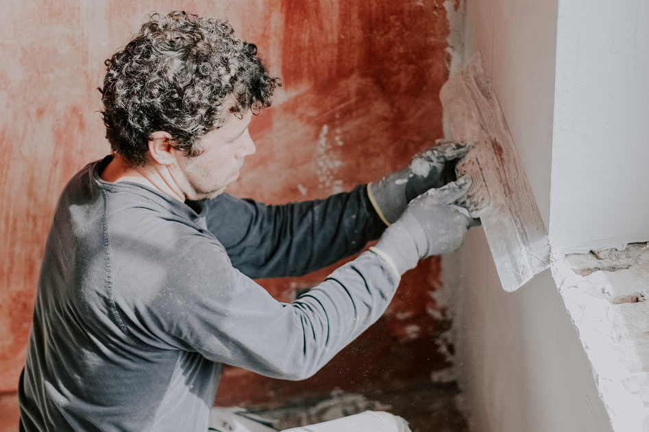 a-young-man-is-putting-putty-on-the-wall-2023-11-27-05-07-11-utc 1